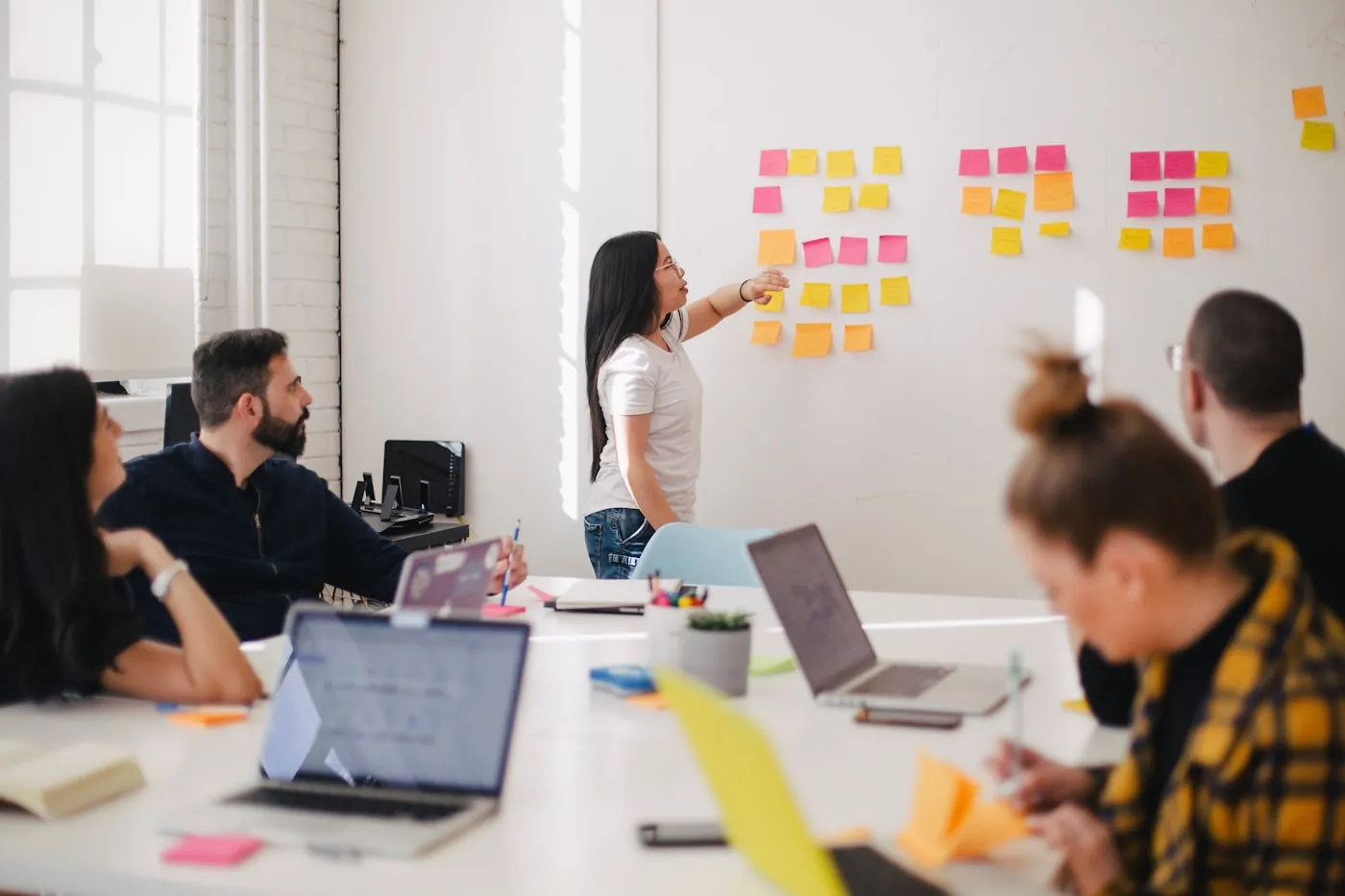 A team designing a process together with sticky notes on the wall
